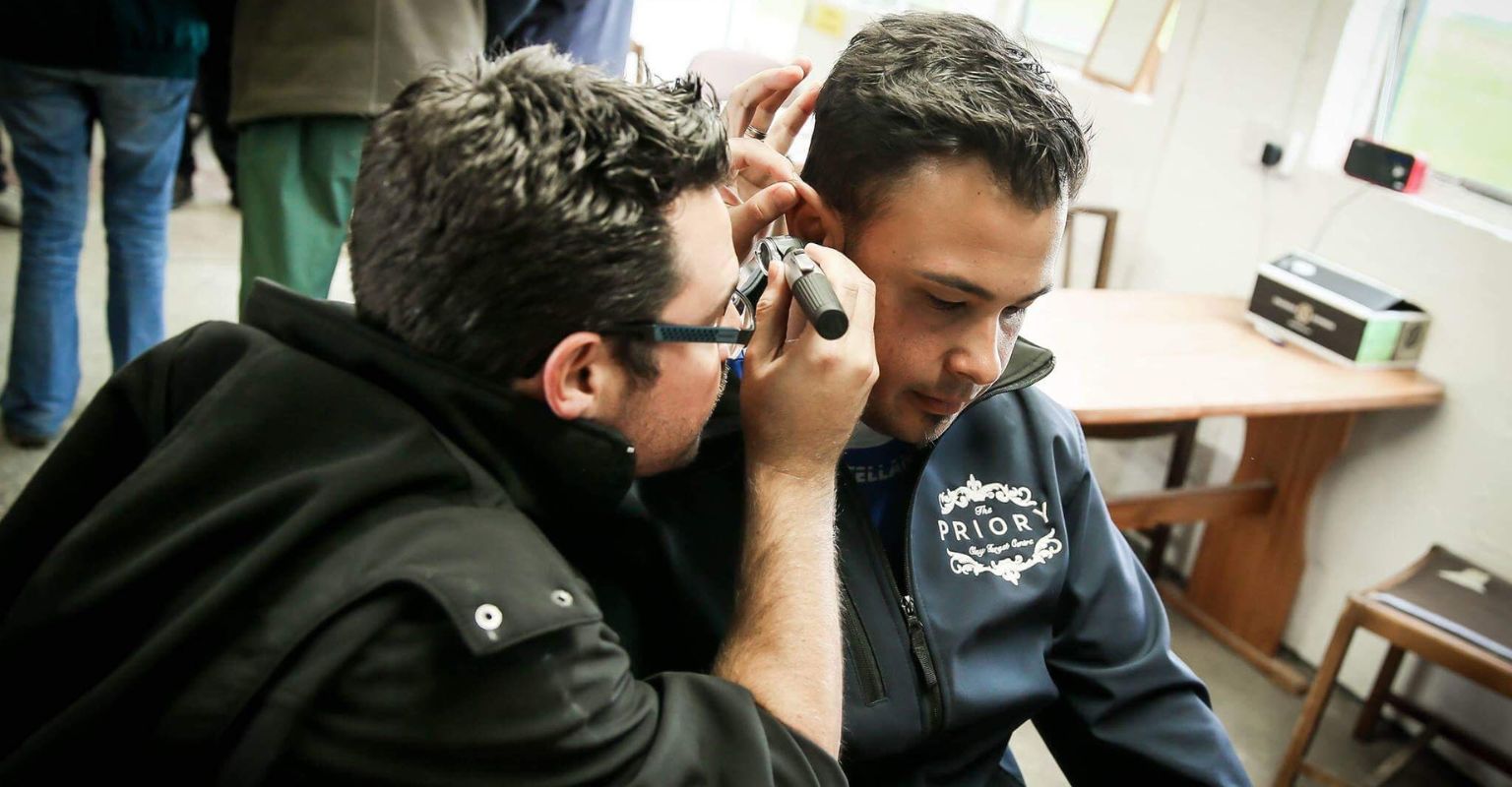 man inspecting ear for custom hearing protection